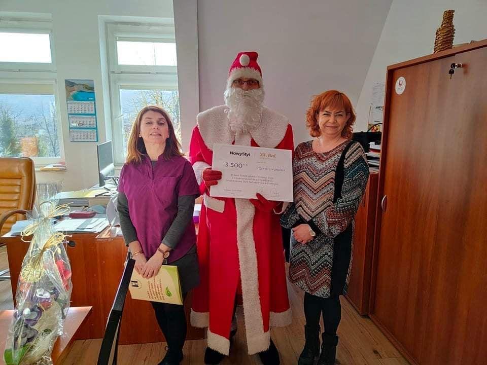 Symboliczny czek z rąk przedstawiciela krośnieńskiej firmy Krzysztofa Dulińskiego (tego dnia w roli św. Mikołaja) odebrały w imieniu podopiecznych PSONI w Przemyślu reprezentujące tę instytucję Małgorzata Dańczak-Maksym i Beata Gumienny. <br/>fot.PSONI Przemyśl