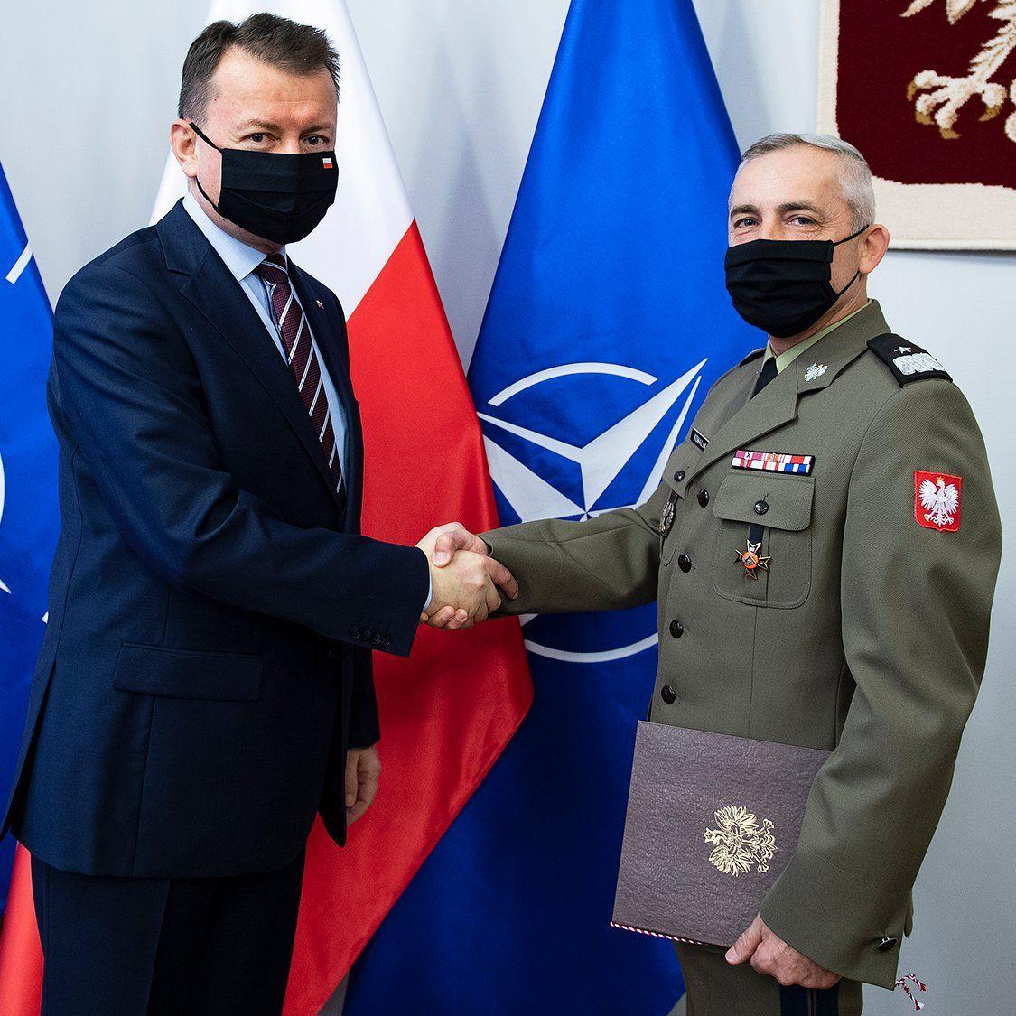 Minister obrony Mariusz Błaszczak wręczający nominację na nowe stanowisko generałowi brygady Rafałowi Kowalikowi (z prawej).<br/>fot.www.gov.pl