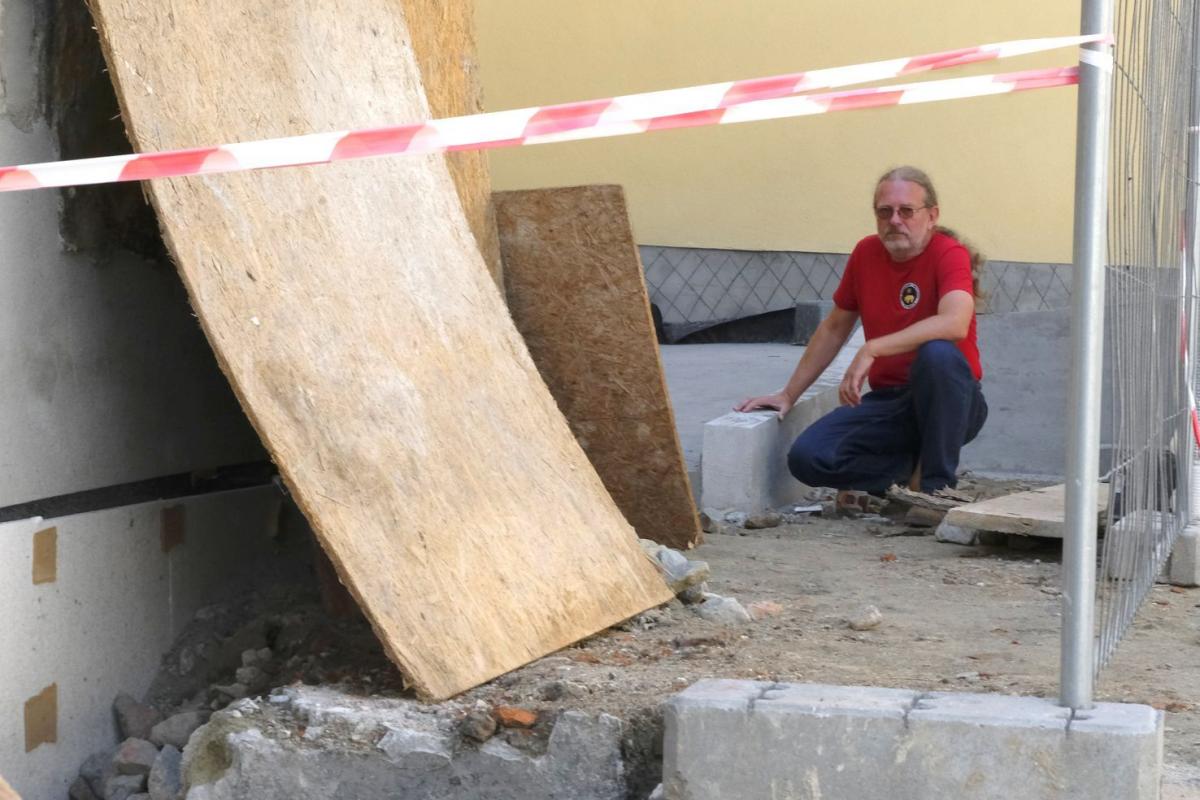 Leszek Koman pokazuje zawalony fragment podwórka, gdzie ma zostać zainstalowana rampa.<br/>fot.Jacek Szwic