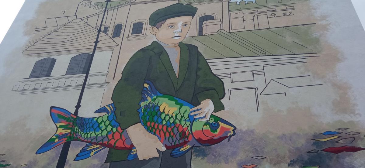 Mural z chłopcem z rybą znajduje się na ścianie kamienicy przy placu Rybim 2. <br/>fot.ze zbiorów własnych