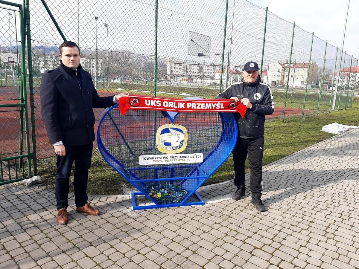 Trzeci przemyski pojemnik na nakrętki stanął na obiekcie sportowym Stadion Juvenia przy ul. Dworskiego. Na zdjęciu Grzegorz Piestrak, prezes Towarzystwa Przyjaciół Dzieci w Przemyślu realizującego akcję „Nakręceni w pomaganie z TPD” oraz szef UKS Orlik Przemyśl Henryk Łaskarzewski, od którego wyszed