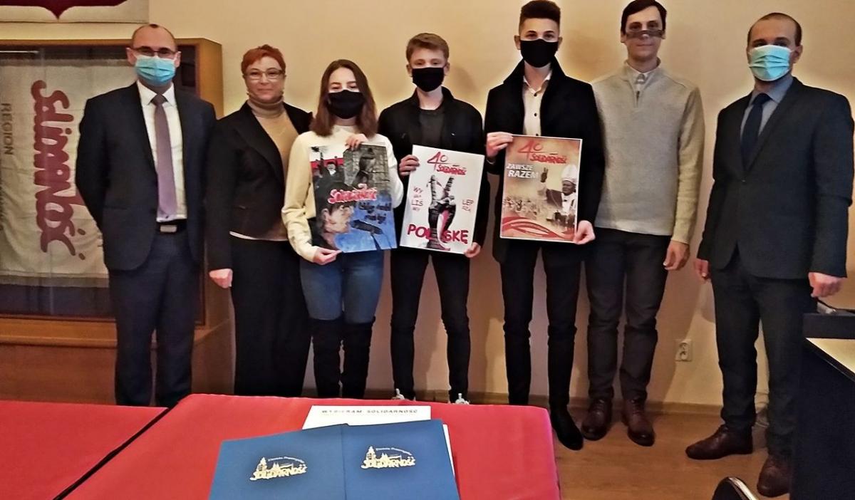 Laureaci konkursu w kategorii szkół średnich ze swoimi nauczycielami, przewodniczącym Regionu Ziemia Przemyska NSZZ „Solidarność” Szymonem Wawrzyszko (pierwszy z lewej) oraz przewodniczącym Rady Miejskiej w Przemyślu Maciejem Kamińskim (pierwszy z prawej).<br/>fot.Mariusz Godos