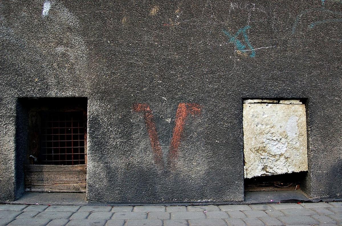 Strzałki kierunkowe są na kamienicach przy ul. Okrzei 8 i 10, natomiast V na kamienicy pod nr 4 i również na „10”.<br/>fot.ze zbiorów własnych