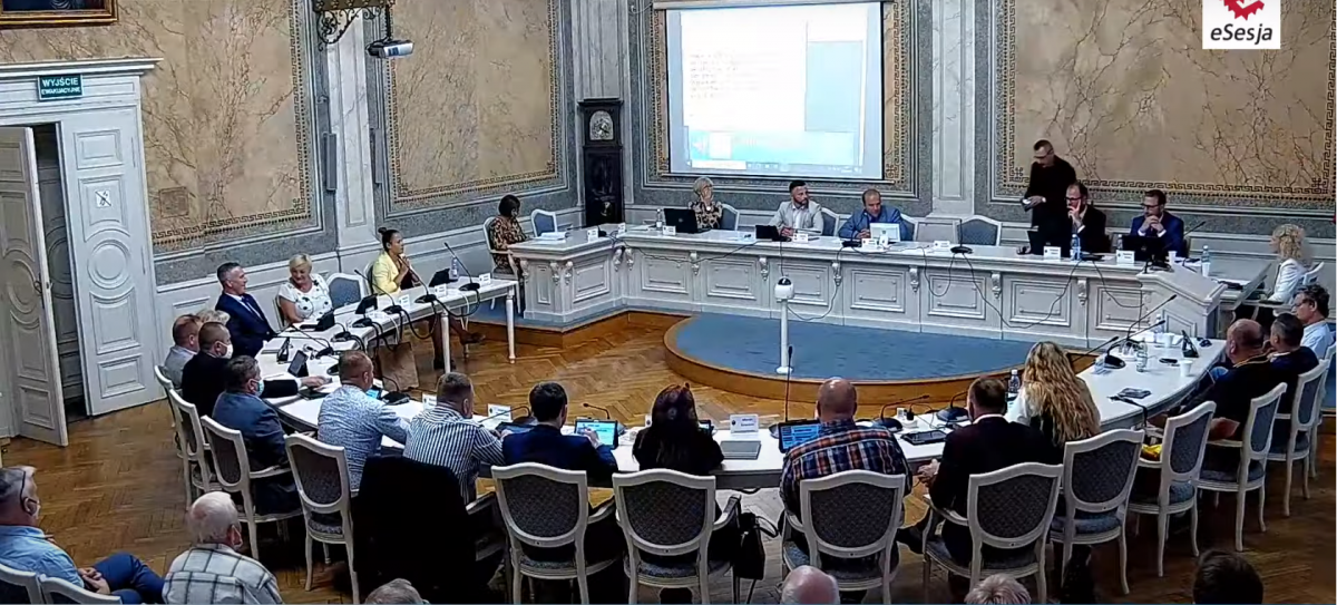 Właśnie wiceprzewodniczący Rady Miejskiej w Przemyślu Janusz Zapotocki (stoi, trzeci z prawej przy prezydialnym stole) sprawdza czy z jego telefonem, szurniętym po prezydialnym stole przez prezydenta miasta Wojciecha Bakuna w stronę swojego zastępcy Bogusława Świeżego, wszystko w porządku. Na szczęś