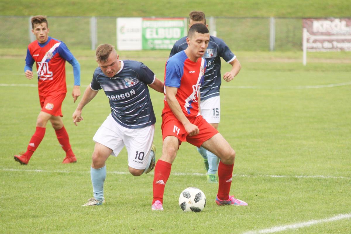 Mateusz Wanat (czerwony strój, na pierwszym planie) strzelił jedyną bramkę dla Polonii Przemyśl w przegranym meczu w Wiśniowej z Wisłokiem.<br/>fot.Kamil Krukiewicz