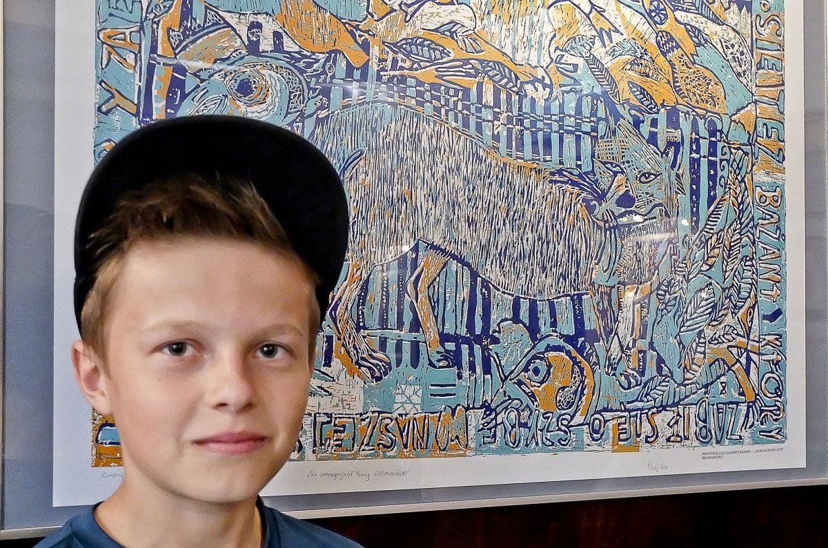 Maciek Kos. W tle jego linoryt „Lis zagryzł zielononóżki”.<br/>fot.Jacek Szwic