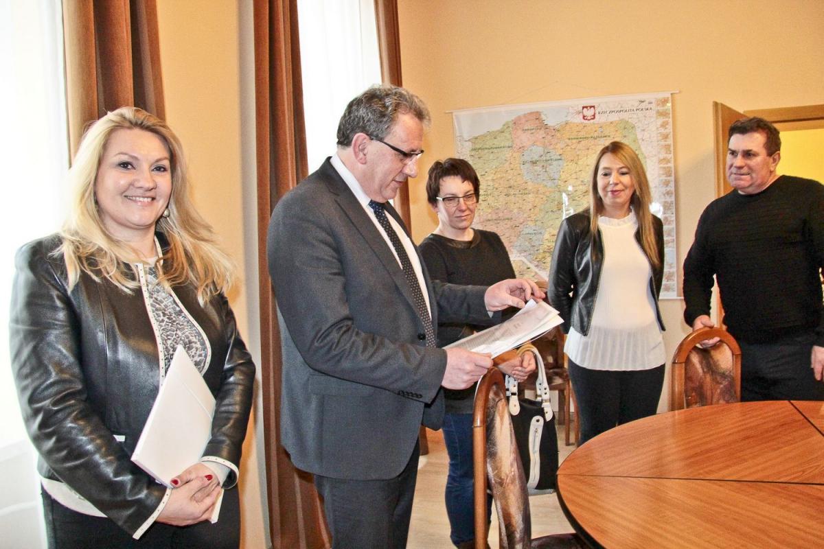„Mówimy stanowcze „nie” przeniesieniu Technikum Drogowo-Geodezyjnego do Zespołu Szkół Budowlanych i Ogólnokształcących” – piszą rodzice w petycji złożonej we wtorek u starosty. Na fotografii reprezentanci rodziców wręczają dokument staroście Tadeuszowi Chrzanowi.  <br/>fot.Roman Kijanka