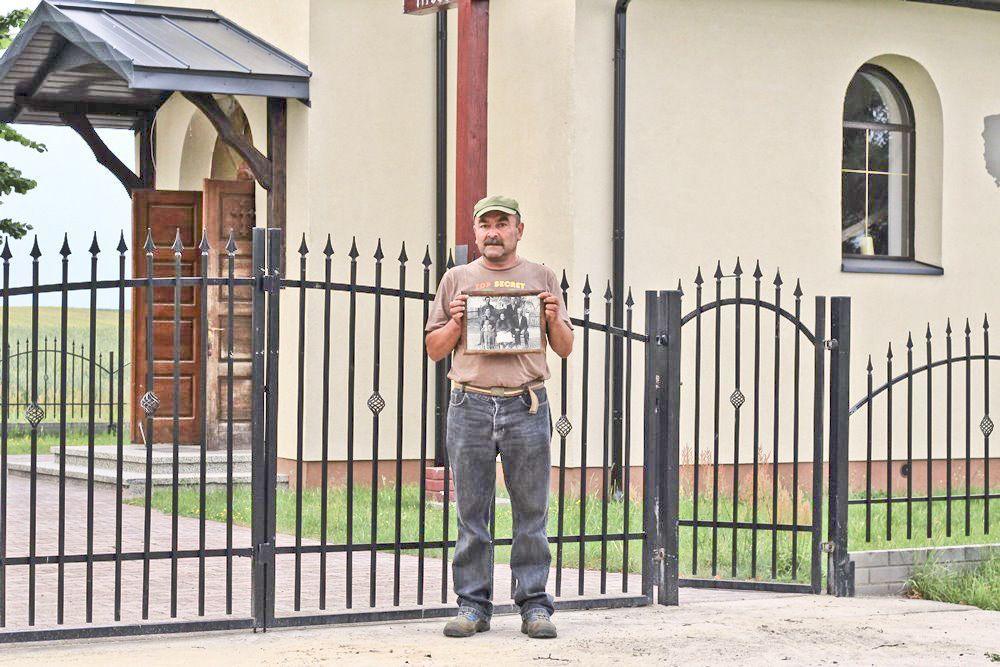 Wiesław Szałański, wnuk Katarzyny Szałańskiej – fundatorki ziemi pod kaplicę. Trzyma fotografię, na której jego babcia z rodziną stoi przed nową kaplicą.<br/>fot.Justyna Zając