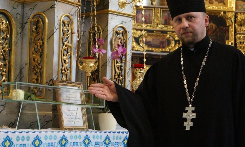 Ksiądz proboszcz zwraca uwagę na dobry stan róży.<br/>fot.Bogusława Pajda