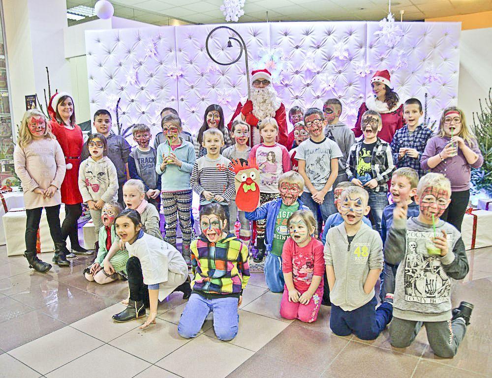Mali klienci DH Szpak i podopieczni świetlicy Oratorium na pamiątkowym zdjęciu ze Świętym Mikołajem i uroczymi elfami (wolontariuszki z PWSW).<br/>fot.Aleksandra Nowotyńska