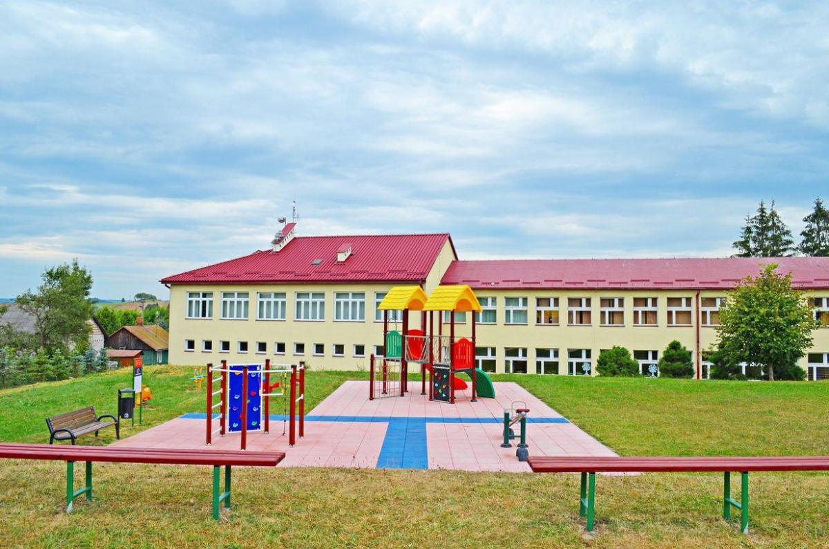 Widok na szkołę od strony boiska i placu zabaw. 