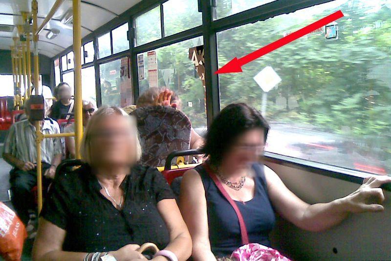 Zdjęcie wykonane przez pasażerkę. Pani, która nie lubi plakatów, usiłuje schować się za siedzenie, a nad nią, na szybie widać resztkę zniszczonego plakatu