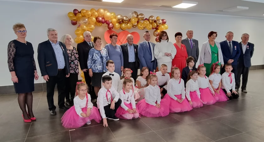 Pamiątkowe zdjęcie jubilatów z dziećmi ze Szkoły Podstawowej w Huwnikach, które uświetniły uroczystość złotych godów./ Zdjęcia UG Fredropol