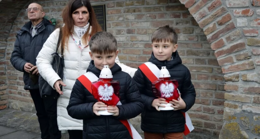 Po mszy św. dalsza część uroczystości odbyła się przy tablicy znajdującej się w murze klasztornym, gdzie znajdują się też urny z ziemią z Huty Pieniackiej. Fot. UM Przemyśl
