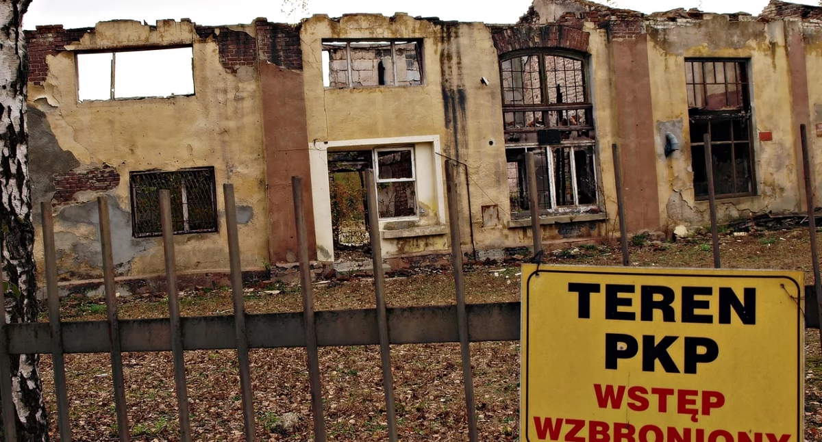 Mijają lata, a na obskurnym ogrodzeniu i ponurych pozostałościach po obiekcie wciąż wisi tabliczka z informacją, że ten grozi zawaleniem, że to teren prywatny oraz że wejście jest zabronione. Fot. Mariusz Godos