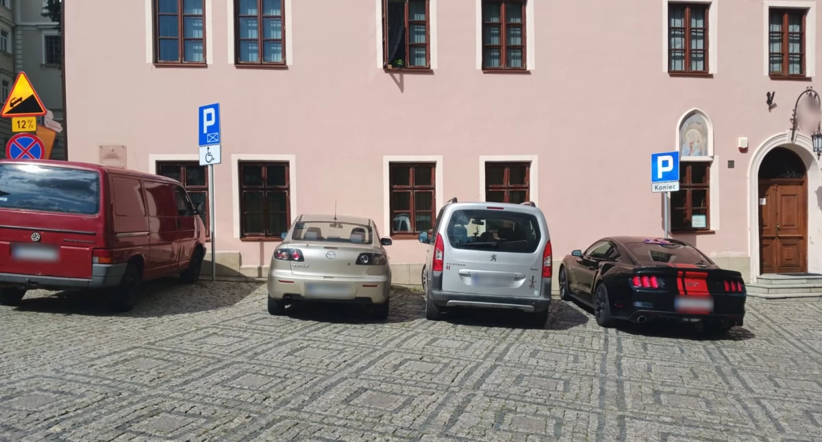Miejsce parkingowe dla osoby niepełnosprawnej obligatoryjnie musi posiadać zarówno oznakowanie pionowe w postaci niebieskiej tabliczki z białym symbolem, jak i oznakowanie poziome na jezdni w postaci wymalowanego na niebiesko obszaru. W przypadku parkingu przy katedrze brakuje tego drugiego./ FOT. ZW