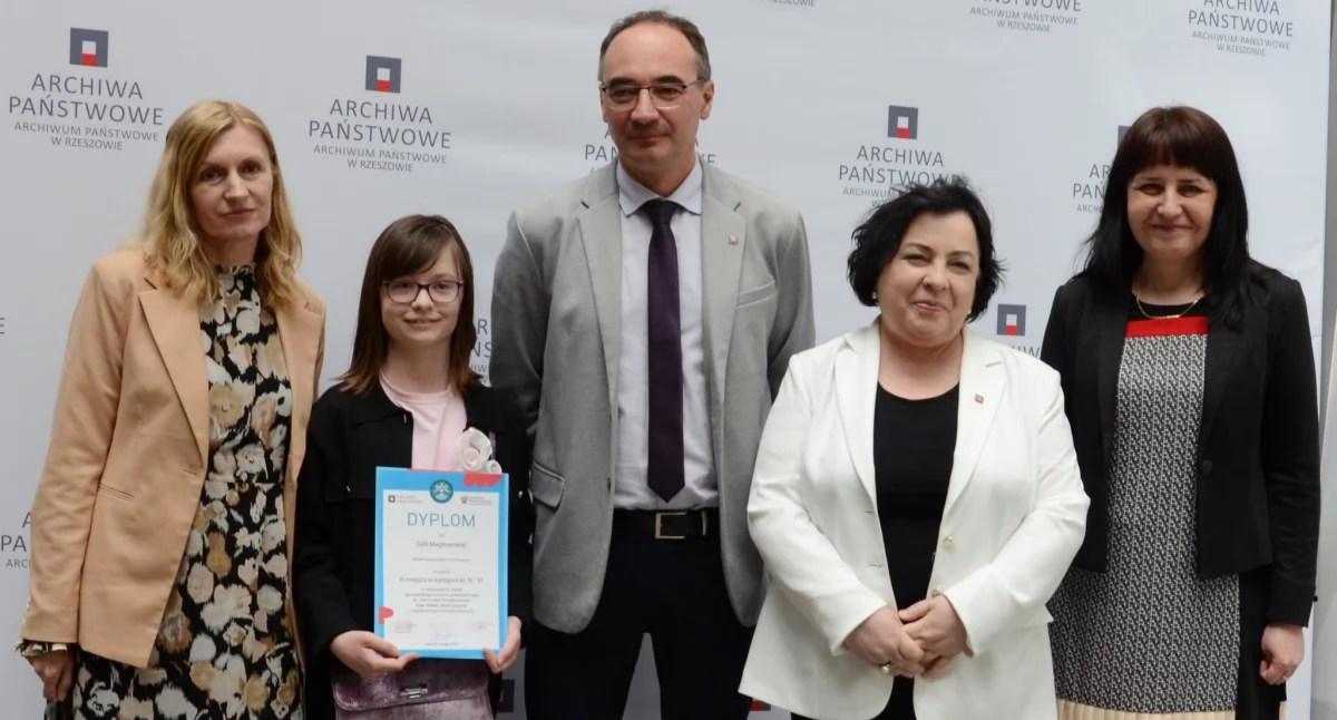 Jedna z finalistek Zofia Magnowska ze Szkoły Podstawowej nr 1 w Żurawicy w towarzystwie nauczycielki Elżbiety Jaroch-Chlastawy (pierwsza z lewej). Obok dyrektor Archiwum Państwowego w Rzeszowie Paweł Dudek, dyrektor Archiwum Państwowego w Przemyślu Elżbieta Laska i Agnieszka Bobowska-Hryniewicz z przemyskiego archiwum. Fot. zbiory własne