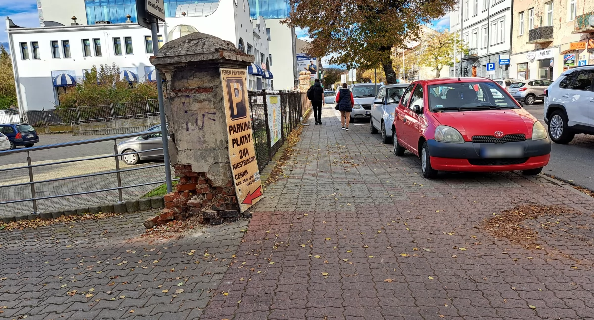 Problematyczny wyjazd z parkingu przy 3 Maja, zlokalizowanego w niedalekim sąsiedztwie przejścia dla pieszych i apteki.  Ile naprawdę widzi kierowca osobówki, który próbuje się włączyć do 3 Maja, jeśli na chodniku tuż przy wyjeździe zaparkowane są samochody?/ FOT. U. Gielo