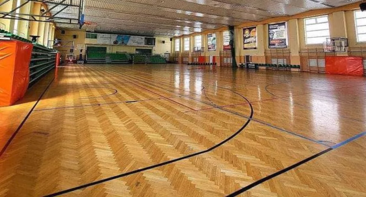 Obecna podłoga w hali POSiR została wykonana kilkanaście lat temu, a zakres prac ograniczył się do wykonania nowej nawierzchni z klepki parkietowej bez ingerencji w podbudowę podłogi. A to przez lata użytkowania sprawiło, że nawierzchnia w wielu miejscach uległa nadmiernym ugięciom, w kilku miejscach doszło do zniszczenia klepek. Fot. POSiR