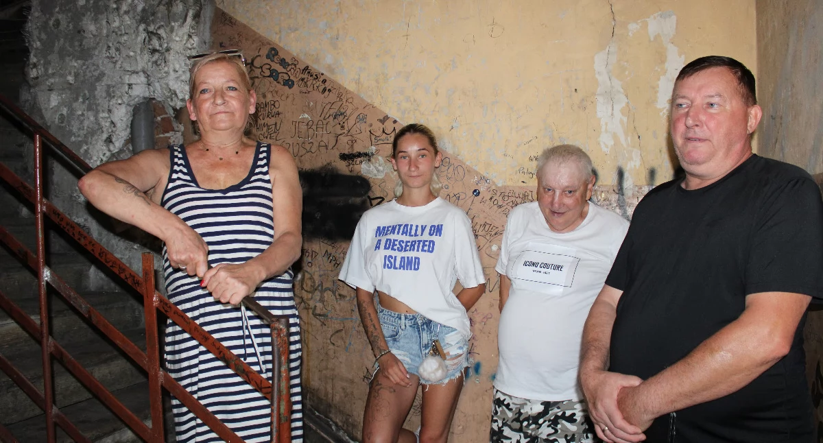 Mieszkańcy kamienicy przy ulicy Smolki 4 od 15 lat nie mogą się doprosić odmalowania osmolonych ścian klatki schodowej, zabezpieczenia odsłoniętych w wyniku pożaru części instalacji oraz remontu kompletnie zniszczonej podłogi. Obawiają się, że sadza, jaka osadziła się na ścianach budynku, nie jest obojętna dla ich zdrowia. Na zdjęciu od lewej: Agata Czura z córką, Andrzej Sulipa oraz Zbigniew Kocan. / FOT. U. Gielo